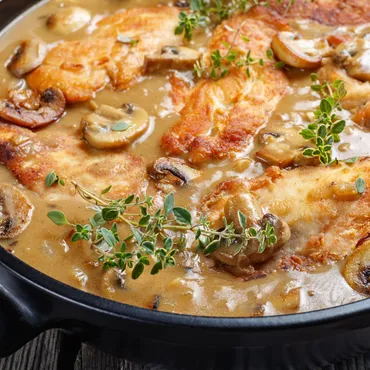 Marsala Braised Chicken with Mushrooms in black skillet